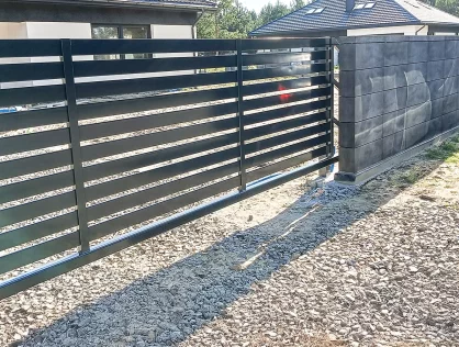 Brama palisadowa w tle biały nowoczesny dom