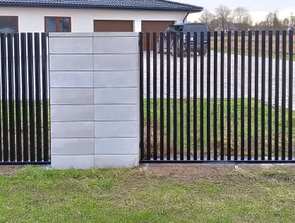 Eleganckie ogrodzenie z paneli pionowych w tle nowoczesny parterowy dom